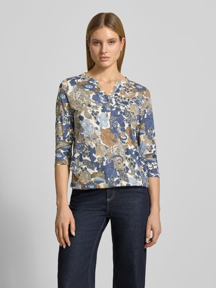 Vrouwenmodel draagt Regular Fit blouse uit viscosemix model 'Felicity' van Soyaconcept, all-over bloemenprint, halflange mouwen, tuniekhals, dames blouse, ruglengte bij maat S 63 cm, vooraanzicht bovenlichaam.