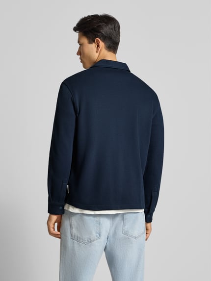 Männermodel trägt Relaxed Fit Hemdjacke aus reiner Baumwolle von Marc O'Polo Denim in Dunkelblau, Sweat-Optik, Ganzkörperansicht Rückansicht.