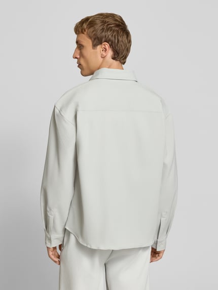 Männermodel trägt Regular Fit Freizeithemd mit Kentkragen und Label-Stitching von Pegador in Hellgrau, glatte Textur, Ganzkörperansicht Rückansicht. Material-Mix mit Stretch-Anteil, Modell 'Troy', Rückenlänge 68 cm, Schulterbreite 50 cm, Ärmellänge 60 cm.