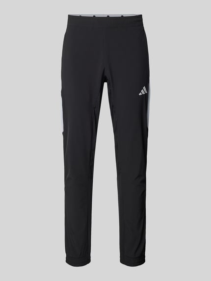 Produktfoto, Slim Fit Trainingshose mit Logo-Print Modell 'Tech' von adidas Training im schwarzen Elastischer-Material-Mix, elastischer Bund und elastische Beinabschlüsse, Logo-Print, Innenbeinlänge 74 cm bei Größe M