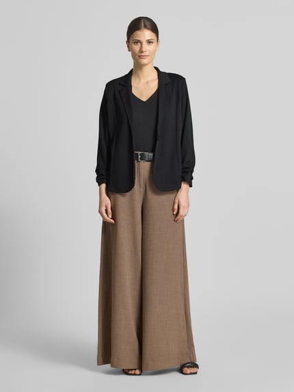 Vrouwenmodel draagt Blazer met Raffungen Modell 'Siham' van Soyaconcept in zwart, elastische materiaalmix, getailleerd, reverskraag, knoopsluiting, ruglengte maat S 58 cm, borstwijdte maat S 50 cm, mouwlengte maat S 54 cm, gladde textuur. Ganzlichaamsvooraanzicht.