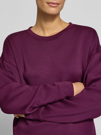 Vrouwenmodel draagt Relaxed Fit sweatshirt uit elastische viscosemix Model 'Ima' van MSCH Copenhagen, diepe paarse kleur, dames sweatshirt, gladde textuur, Nahaufnahme Oberkörper.