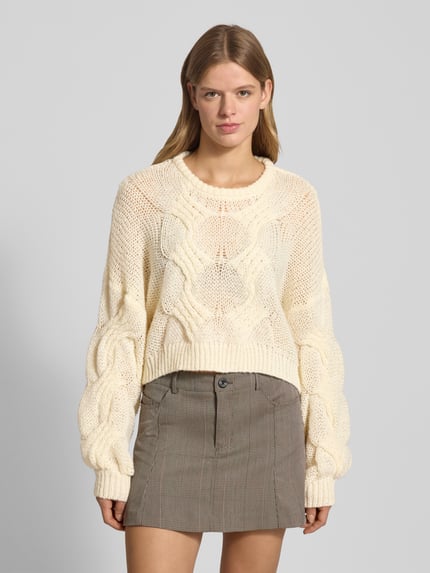 Frauenmodel trägt Cropped Strickpullover mit gerippten Abschlüssen Modell 'LOES' von Noisy May in Creme, lockerer Schnitt, Vorderansicht, Nahaufnahme Oberkörper.