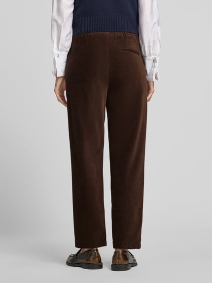 Frauenmodel trägt Relaxed Fit Cordhose aus reiner Baumwolle von Marc O'Polo in dunkelbraun, samtige Textur, Ganzkörperansicht Rückansicht. Damen Cordhose von Marc O'Polo.