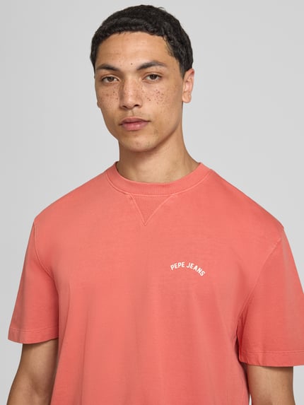 Männermodel trägt Regular Fit T-Shirt aus reiner Baumwolle Modell 'John Tee' von Pepe Jeans in Koralle, Herren T-Shirt, Nahaufnahme Oberkörper.