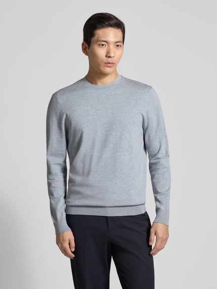 Męski model nosi Regular Fit Pullover aus Lyocell-Mix mit Seiden-Anteil od Profuomo, jasnoszary melanż, okrągły dekolt, krój regular fit, dzianinowa faktura, elastyczne wykończenia, widok całej sylwetki z przodu.