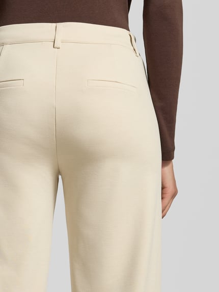 Frauenmodel trägt Wide Fit Stoffhose mit Viskose-Anteil Modell 'Nanni' von FREE/QUENT in Beige mit Gesäßtaschen, Detailaufnahme Rückansicht, elastischer Material-Mix, Kontext: Damen Stoffhose, Knopf- und Reißverschluss, Bundweite bei Größe S 40 cm, Innenbeinlänge 79 cm.