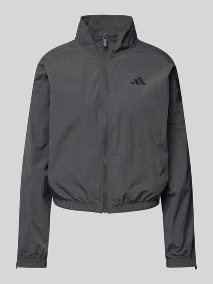 Produktfoto, Regular Fit Jacke mit Stehkragen von adidas Sportswear in Dunkelgrau, Logo-Print, Reißverschluss, elastische Abschlüsse, glatte Textur