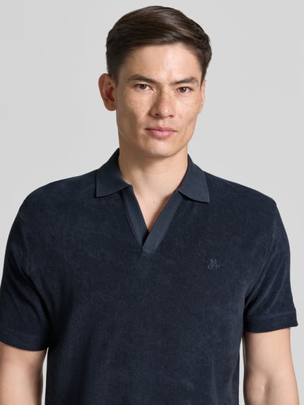Mężczyzna nosi Regular Fit Poloshirt aus reinem Baumwoll-Frottee od Marc O'Polo, ciemnogranatowa frota, logo, Nahaufnahme Oberkörper.