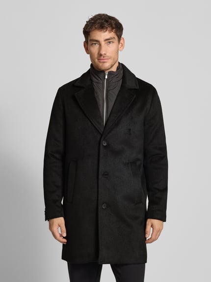 Männermodel trägt Mantel mit Stehkragen Modell 'BLASTANFORD' von Jack & Jones Premium, schwarz, Material-Mix, Ganzkörperansicht von vorne.