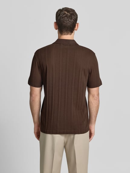 Männermodel trägt Regular Fit Poloshirt aus Baumwoll-Mix Modell 'TRAVIS' von SELECTED HOMME in Braun, Struktur, Ganzkörperansicht Rückansicht.