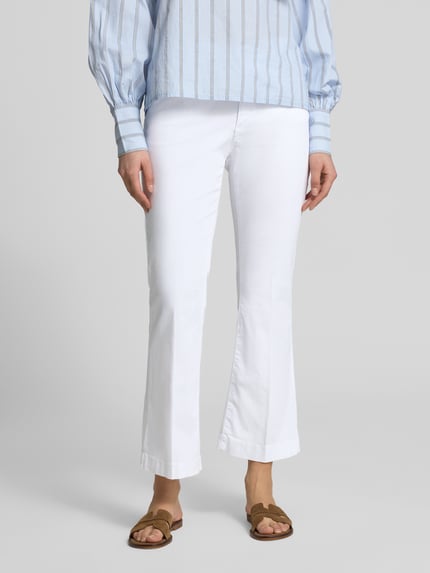 Frauenmodel trägt Bootcut Jeans im 5-Pocket-Design Modell 'Mary' von Brax aus Baumwoll-Lyocell-Mix mit Stretch-Anteil, Nahaufnahme Unterkörper.