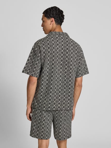 Männermodel trägt Boxy Fit Freizeithemd im Allover-Look Modell 'ZANDER' von Redefined Rebel aus reiner Baumwolle, Ganzkörperansicht Rückansicht.