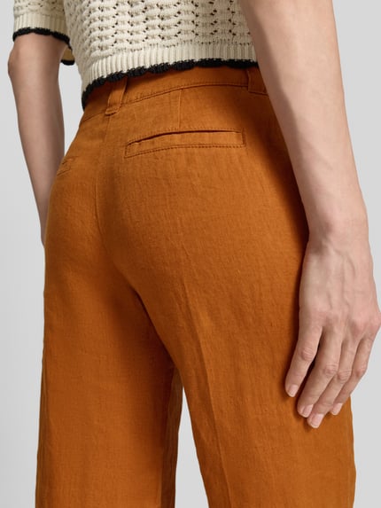 Frauenmodel trägt Leinenhose mit Eingrifftaschen von Christian Berg Woman in Orange, Reines Leinen, Regular-Fit, Nahaufnahme Hüfte.