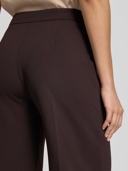 Frauenmodel trägt Straight Fit Stoffhose mit Bügelfalten von Rinascimento, Material-Mix, elastischer Bund, Detailaufnahme seitlich