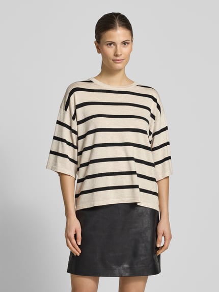 Frauenmodel trägt Strickshirt aus Viskose-Mix Modell 'Conny' von FREE/QUENT, beige mit schwarzen Streifen, Relaxed Fit, Nahaufnahme Oberkörper.