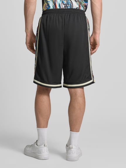 Männermodel trägt Shorts aus Mesh mit Kontraststreifen von COLUCCI in Schwarz mit Gerader-Schnitt, Ganzkörperansicht Rückansicht. Bundweite 37 cm, Innenbeinlänge 24 cm, elastischer Bund.