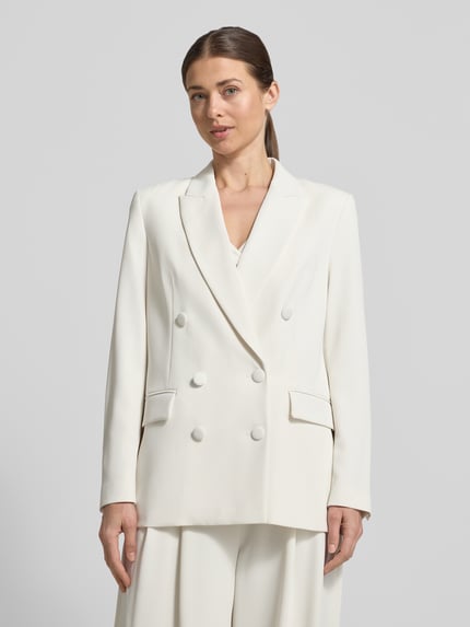 Kobiece model nosi Regular Fit Blazer mit Pattentaschen od Christian Berg Cocktail, mieszanka materiałów z dodatkiem streczu, krój regular fit, dwurzędowy, kołnierz z połami, kieszenie z patką, długość tyłu w rozmiarze 36: 70 cm, kolor kremowy, gładka tekstura, prostokątne kształty, całkowity widok z przodu