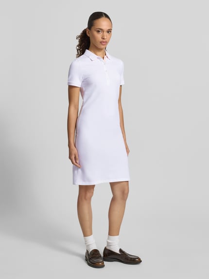 Frauenmodel trägt Knielanges Polokleid mit Label-Stitching von Gant aus Baumwoll-Elasthan-Mix, Gerader-Schnitt, Knielänge, Knopfleiste, Ganzkörperansicht von vorne.