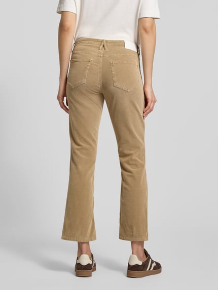 Frauenmodel trägt Flared Fit Cordhose im 5-Pocket-Design Modell 'Enja' von OPUS PANTS im beigefarbenen Baumwoll-Mix, Ganzkörperansicht Rückansicht.