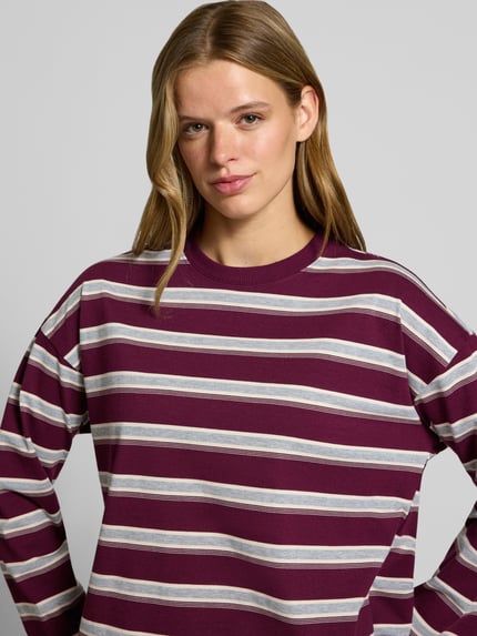 Vrouwenmodel draagt Relaxed Fit Sweatshirt uit katoenmix model 'Ember' van NOISY MAY®, gestreept, ronde hals, lange mouwen, detailopname bovenlichaam.