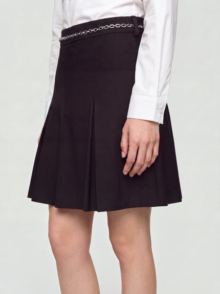 Frauenmodel trägt Minirock mit Kettendetail Modell 'Rejulia-1' von HUGO, unifarben, ausgestellte Rockpartie, keine Taschen, Nahaufnahme Oberkörper.