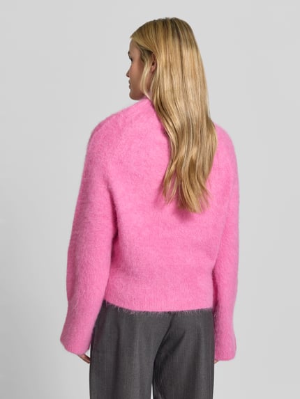 Frauenmodel trägt Sweatshirt mit Mock Neck Modell 'PROMISY' von IRO in Pink, strukturierte Strickoptik, gerippte Abschlüsse, Ganzkörperansicht Rückansicht.