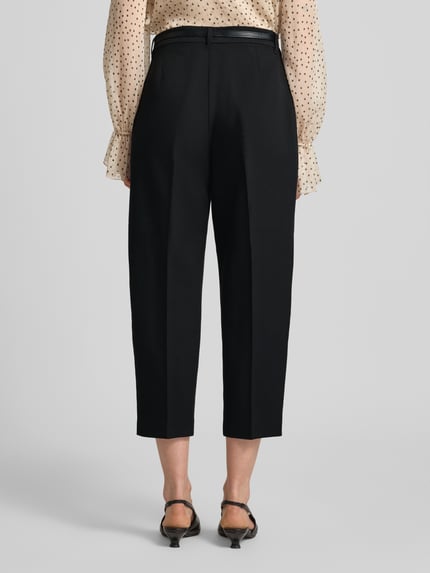 Frauenmodel trägt Barrel Fit Stoffhose mit Gürtel Modell 'ELMA' von Vero Moda, unifarben schwarz, Mid Waist, Ganzkörperansicht Rückansicht