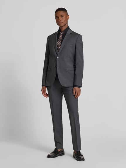 Männermodel trägt Slim Fit Business-Hemd mit Stretch-Anteil Modell 'Hank Hai' von BOSS, unifarben, Haifischkragen, Ganzkörperansicht von vorne.