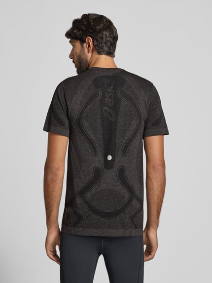 Mężczyznamodel nosi Slim Fit RUNNING T-Shirt Modell 'ROAD' od ASICS, czarny z metalicznym nadrukiem, krój slim fit, widok całej sylwetki z tyłu, długość tyłu w rozmiarze M: 72 cm.