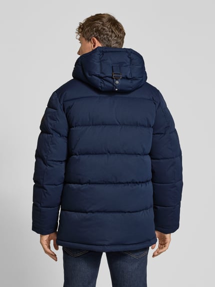 Männermodel trägt dunkelblaue Steppjacke mit Brusttasche von S.OLIVER CASUAL, unifarben, strukturierte Oberfläche, Longline, Ganzkörperansicht Rückansicht.