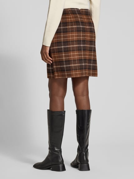 Frauenmodel trägt Rock mit formgebenden Nähten von S.OLIVER CASUAL in mehrfarbigem, kariertem Wollmix, Mini, Details durch sichtbare Nähte, Ganzkörperansicht Rückansicht.