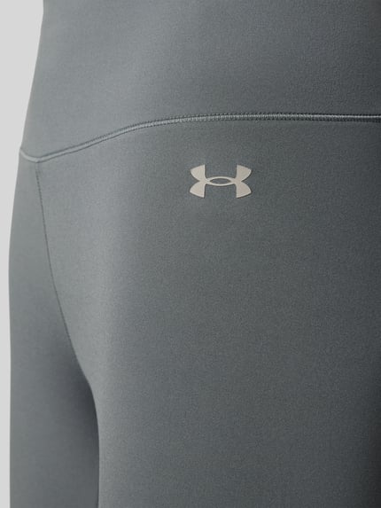 Produktfoto, Slim Fit Leggins mit semitransparenten Partien Modell 'Motion' von Under Armour z elastycznej mieszanki materiałów, krój slim fit, półprzezroczysty materiał, kieszeń na nogawce, szeroki pas, nadruk z logo, skrócona długość, kolor szary, gładka faktura