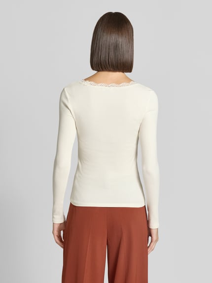 Frauenmodel trägt Slim Fit Langarmshirt aus Baumwoll-Mix von Jake*s Casual in Creme mit feiner Spitze am Halsausschnitt, Ganzkörperansicht Rückansicht.