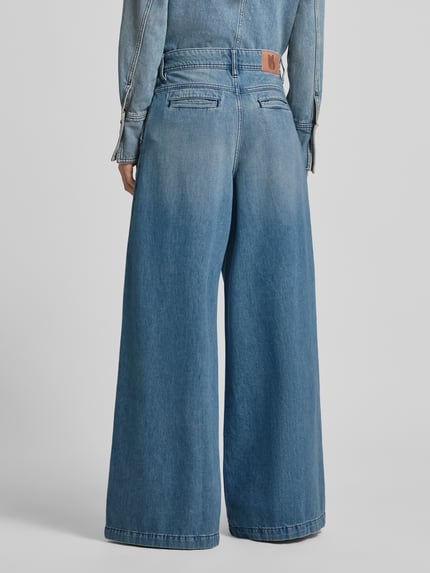 Vrouwenmodel draagt Wide Leg Jeans met plooien model 'TOBY' van Bash, lichtblauwe katoenen denim met steekzakken, detailopname rugaanzicht.