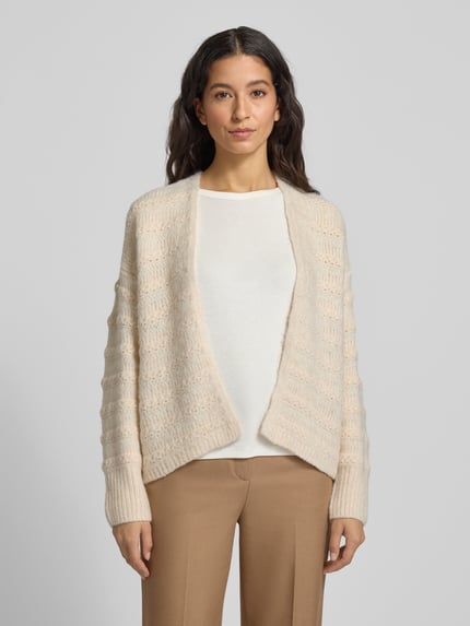Frauenmodel trägt Strickjacke mit Strukturmuster Modell 'Wave' von FREE/QUENT, cremefarben, Relaxed Fit, Materialmix mit Woll-Anteil, Ganzkörperansicht von vorne.