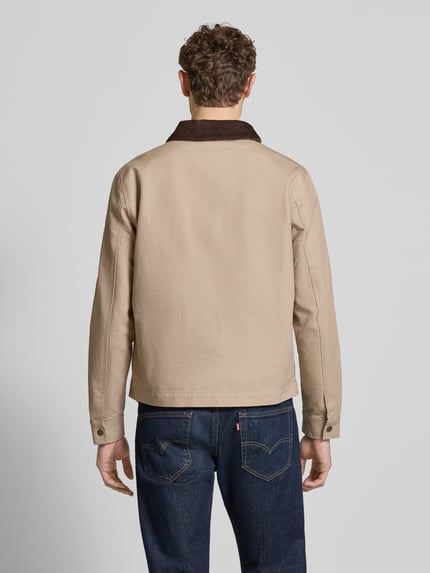 Männermodel trägt Regular Fit Jacke mit Umlegekragen von MCNEAL in Beige mit braunem Kragen aus Baumwolle, Rückansicht, Ganzkörperansicht. Rückenlänge 66 cm, Schulterbreite 48 cm, Brustweite 60 cm, Ärmellänge 68 cm, mit Brusttasche, Eingrifftaschen und Reißverschluss.