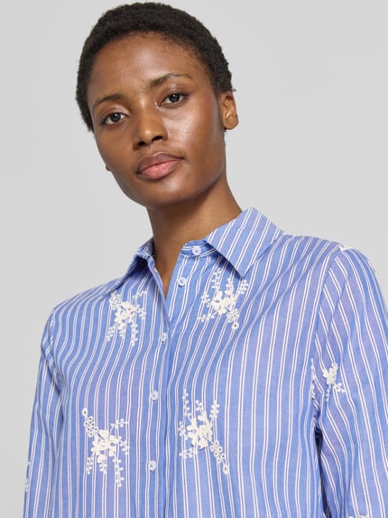 Frauenmodel trägt Regular Fit Langarmbluse aus reiner Baumwolle Modell 'STYLE.VICA' von Brax in Blau mit weißen Streifen und Stickerei, Nahaufnahme Oberkörper, Damen Langarmbluse von Brax.