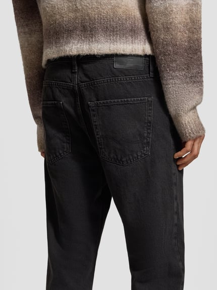 Männermodel trägt Relaxed Fit Jeans mit Eingrifftaschen Modell 'CHRIS' von Jack & Jones, Reine Baumwolle, schwarze Waschung, Detailaufnahme Rückansicht.