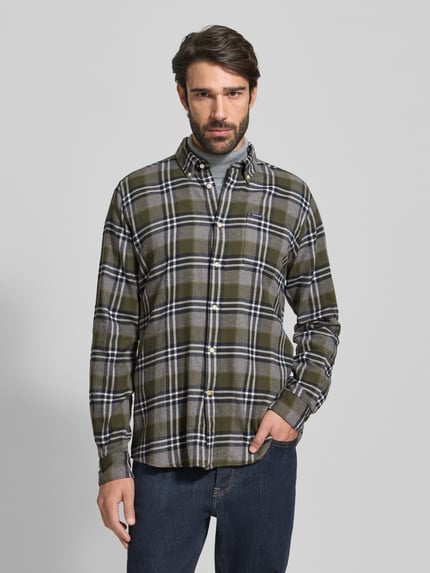 Männermodel trägt Slim Fit Freizeithemd aus reiner Baumwolle von Barbour mit Gitterkaro, Button-Down-Kragen, Khaki-Tönen, Ganzkörperansicht von vorne.