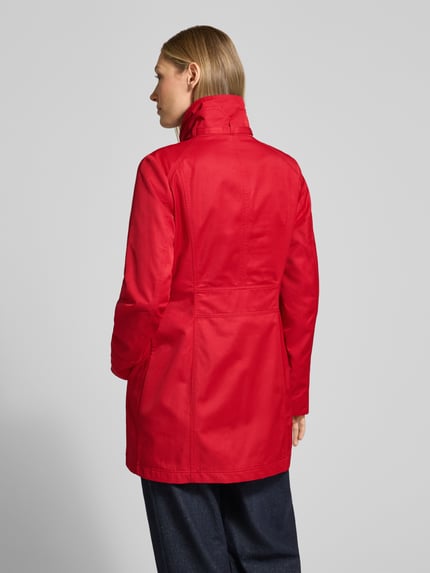 Frauenmodel trägt Trenchcoat mit Stehkragen und Eingrifftaschen von Fuchs Schmitt in Rot, Baumwoll-Mix, tailliert, Ganzkörperansicht Rückansicht.