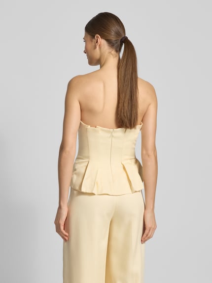 Vrouwenmodel draagt Slim Fit Top mit gelegten Falten van Jake*s Cocktail in lichtgeel, schoudervrij, naadrits, ruglengte 32 cm, achteraanzicht hele lichaam
