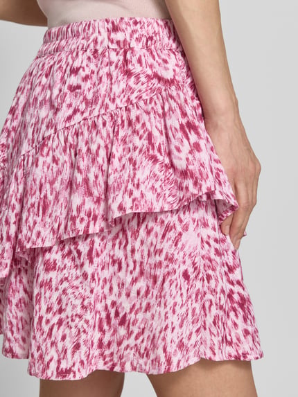 Vrouwenmodel draagt minirok met volantzoom model 'Vildea' van mbyM in roze-wit print, puur katoen, A-lijn, elastische band, detailopname heup