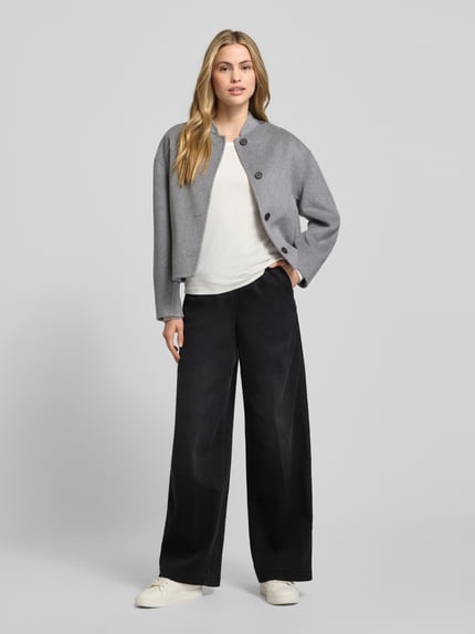 Frauenmodel trägt Jeans mit elastischem Bund von MAC, weiter Schnitt, Baumwoll-Mix, Tunnelzug, Eingrifftaschen, Ganzkörperansicht von vorne.
