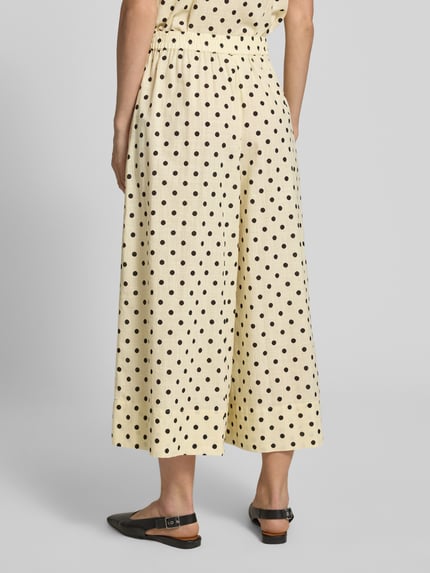 Vrouwenmodel draagt Culotte im Allover-Look Modell 'Nada' van My Essential Wardrobe in crème met zwarte stippen, wide leg van pure katoen, elastische tailleband, detailopname rugaanzicht, context: elegante dames culotte, taillewijdte maat 36: 38 cm, binnenbeenlengte maat 36: 58 cm.