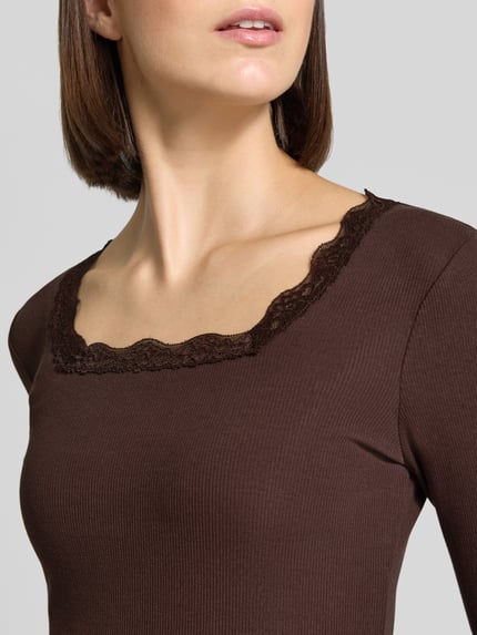 Frauenmodel trägt Slim Fit Langarmshirt aus Baumwoll-Mix von Jake*s Casual in Dunkelbraun mit Spitzendetails, Nahaufnahme Oberkörper.