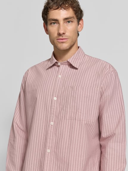Männermodel trägt Relaxed Fit Freizeithemd aus reiner Baumwolle von Jake*s Studio Men, rosa mit feinen Streifen, Nahaufnahme Oberkörper.