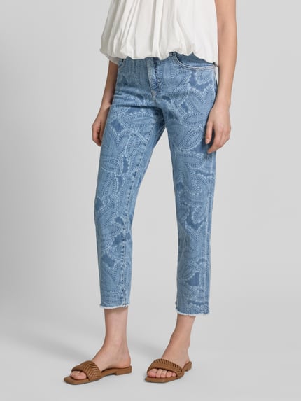 Frauenmodel trägt Slim Fit Jeans im 5-Pocket-Design mit Fransensaum von Marc Cain, hellblauer Baumwoll-Mix mit Muster, Nahaufnahme Unterkörper.