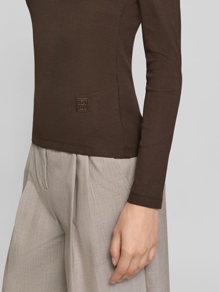Frauenmodel trägt Regular Fit Langarmshirt aus Baumwoll-Mix von Oui in Braun mit Label-Stickerei, Nahaufnahme Oberkörper, Rückenlänge 56 cm.