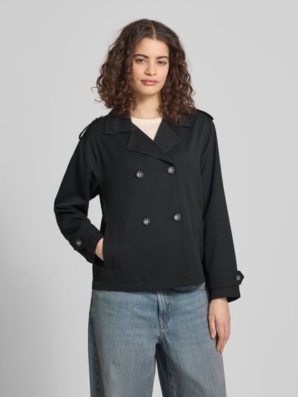 Frauenmodel trägt Regular Fit Trenchcoat-Jacke mit Reverskragen Modell 'HANNAH' von Only, unifarben, doppelreihige Knöpfe, Ganzkörperansicht von vorne.